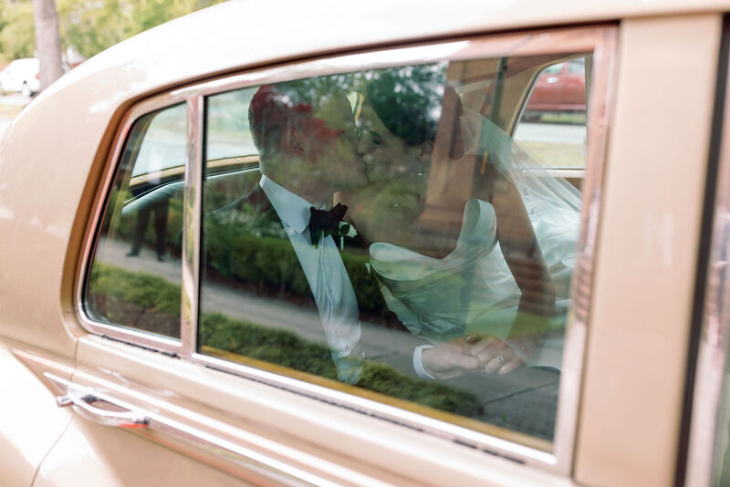 Bride and Groom, Getaway Car, Rolls Royce, Kiss in the Car, Side Window View, White Strapless Wedding Dress, Black Tux, Black Bow Tie, White Undershirt, Wedding Day Photography, Just Married, Couples Photo, After the Ceremony, Husband and Wife, Knot Too Shabby Events, Wilmington Wedding Planner, NC Wedding Planer, 